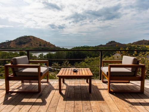two chairs and a table on a deck with a view at Menjaga Bay in Labuan Bajo