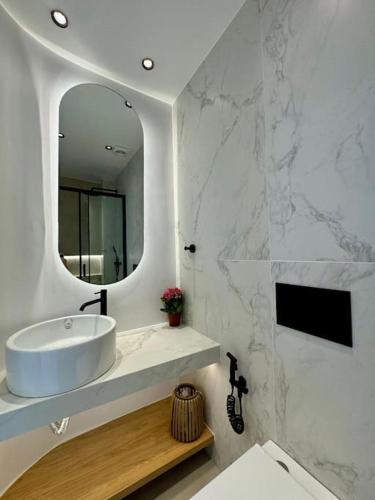 a white bathroom with a sink and a mirror at BlueMotion - CityView in Piraeus