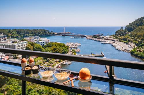a view of a river from a balcony with bowls of food at Hotel Yeon in Seogwipo