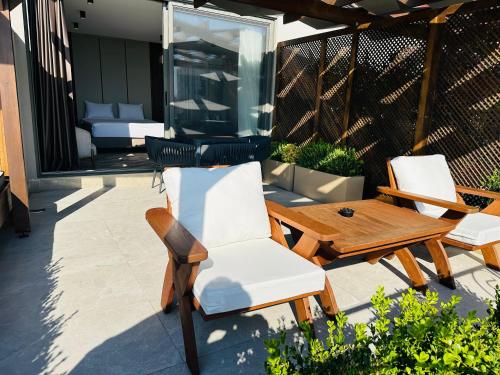two chairs and a wooden table on a patio at Monalisa Hotels KUŞADASI in Kusadası