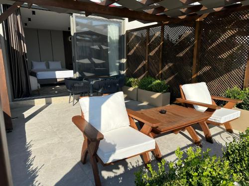 a patio with two chairs and a wooden table and a table and chairs at Monalisa Hotels KUŞADASI in Kusadası