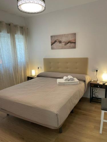 a bedroom with a bed with two towels on it at Apartamentos ANDASOL in Chipiona