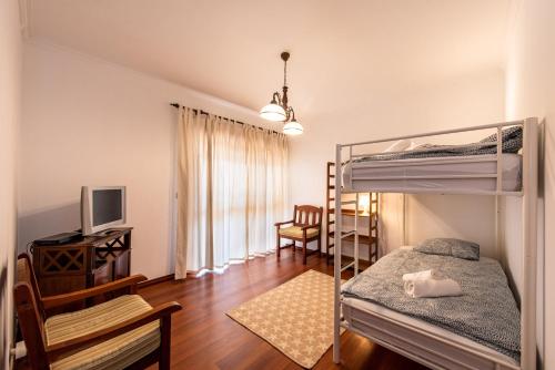 a bedroom with a bunk bed and a television at Cantinho alegre em Cascais in Cascais