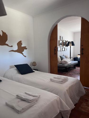 a bedroom with two beds with a bird decal on the wall at Alentempo in Aldeia de Brescos