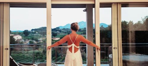 a woman standing in front of a window looking out at GioiaVitae - Bed-in-Botte - Dormire in vigna in Luogosano