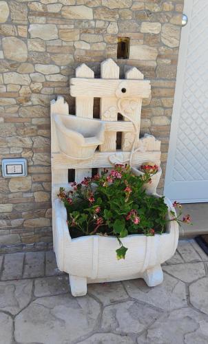 a wooden planter with flowers in it next to a door at GioiaVitae - Bed-in-Botte - Dormire in vigna in Luogosano