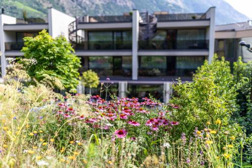 a garden with flowers in front of a building at Boutique Hotel AMARIL in Castelbello-ciardes