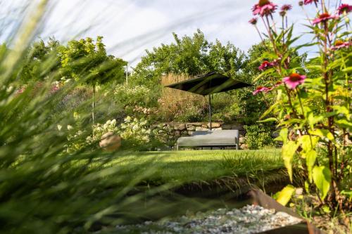 a park bench in a garden with flowers at Boutique Hotel AMARIL in Castelbello-ciardes