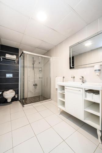 a bathroom with a shower and a sink and a toilet at Manolya Hotel in Kérynia