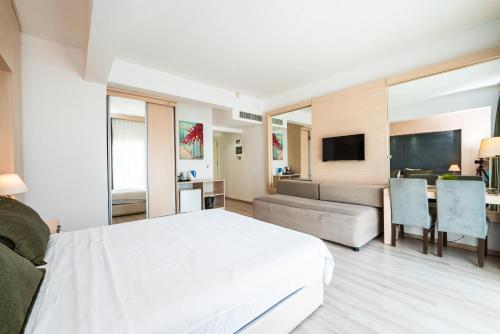a bedroom with a white bed and a living room at Manolya Hotel in Kérynia