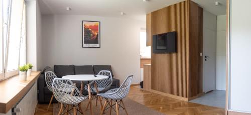 a living room with a table and chairs and a couch at Apartament Słoneczny Rabka Zdrój in Rabka-Zdroj