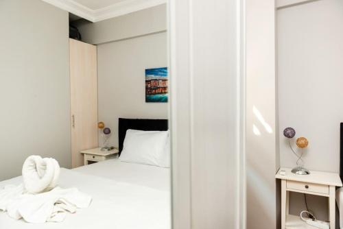 a bedroom with a white bed and two tables at Qbra House 2BR Central Apt Walk to Landmarks in Istanbul