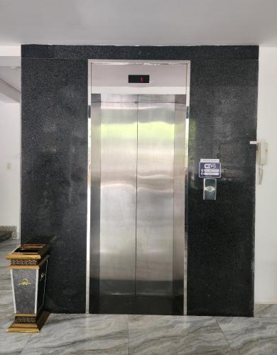 a elevator in a room with a black wall at THẢO AN 2 HOTEL Huế in Thôn Lại Thê