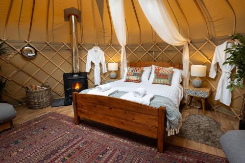 a bedroom with a bed in a tent at Yurtshire Eavestone Lake - Willow in Ripon