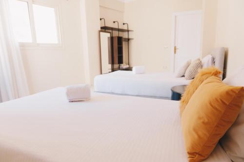 a bedroom with two beds and a yellow pillow at VIDA by Elegant Hospitality in Cairo