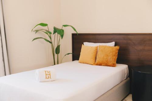 a bed with two pillows and a plant on it at VIDA by Elegant Hospitality in Cairo