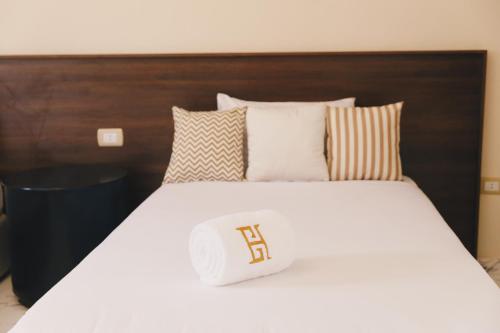 a bed with a white comforter and pillows at VIDA by Elegant Hospitality in Cairo