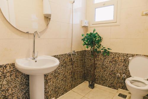 a bathroom with a sink and a toilet and a mirror at VIDA by Elegant Hospitality in Cairo