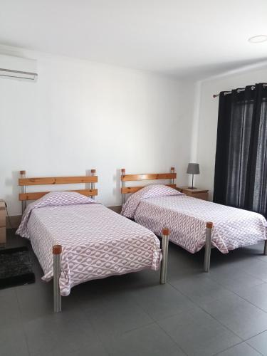 two beds sitting next to each other in a room at Casa da Bella in Velas