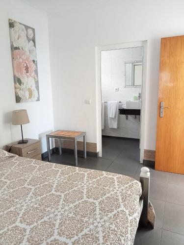 a bedroom with a bed and a bathroom with a sink at Casa da Bella in Velas