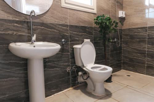 a bathroom with a toilet and a sink at VIDA by Elegant Hospitality in Cairo