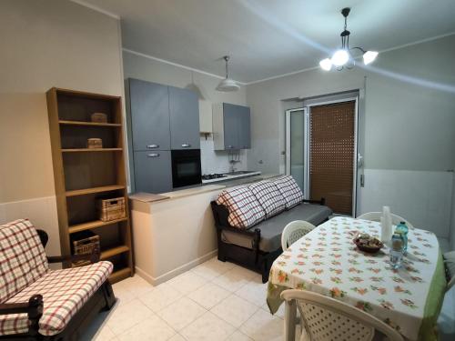 Una pequeña sala de estar con una mesa y un sofá. en CASA al MARE, en Ladispoli