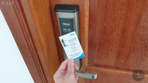 a person is holding a card in a door at Vy An Hotel in Bao Loc