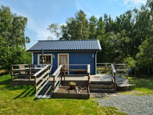 a blue tiny house in a yard with a fence at Lussebo 9 in Lidköping