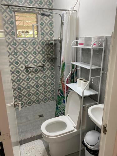 a small bathroom with a toilet and a sink at Vacation Garden Home with kiddie pool, central aircon, Netflix, billiards, table tennis and karaoke in Cavite