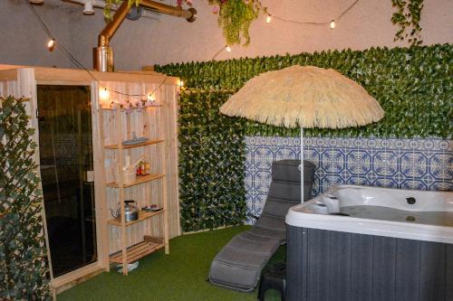 a bathroom with a tub and a chair and an umbrella at Villa Casa da Rosa, com piscina privada in Carvalheira Grande