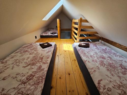 two beds in a attic room with a ladder at Chalupa u Rádlů in Domažlice