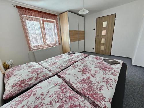 a bedroom with a large bed with red and white sheets at Chalupa u Rádlů in Domažlice