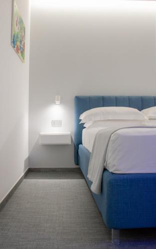 a bedroom with two beds and a blue headboard at Papavero Giallo B&B in Le Castella
