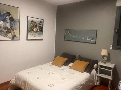 une chambre avec un lit et des tableaux au mur dans l'établissement Villa moderne, à Monfort