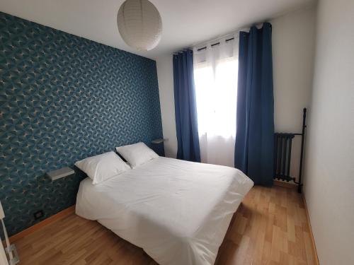 - une chambre avec un lit blanc et un mur bleu dans l'établissement Cosy 2 Pièces proche Paris, à Les Pavillons-sous-Bois
