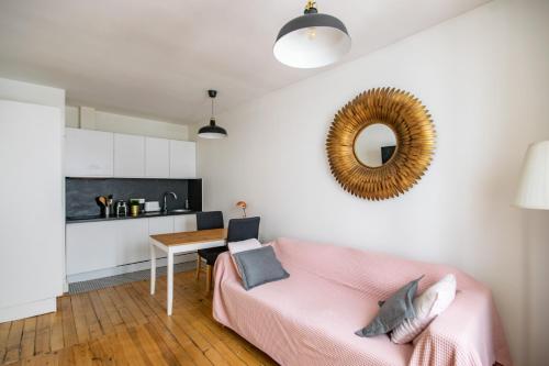 - un salon avec un canapé rose et un miroir dans l'établissement Cosy au Chateau et Bois Métro L1, à Vincennes