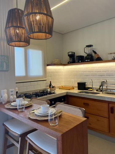 a kitchen with a table with chairs and two lights at Sunny Kite House Prea in Prea