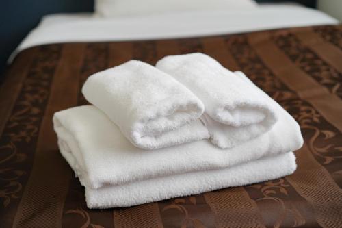 a pile of white towels sitting on a table at 沖縄空手ホテル アイオライト豊見城 in Tomigusuku