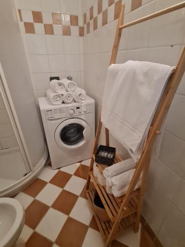 a bathroom with a washing machine and a towel at Appartamento El Feudo in Tesero