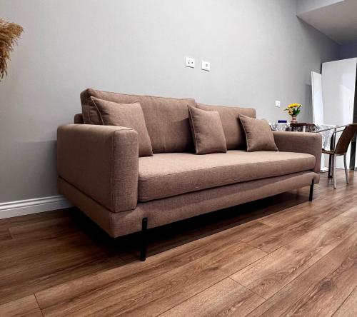 a brown couch in a living room with a table at Arvi Rooms in Lukovë