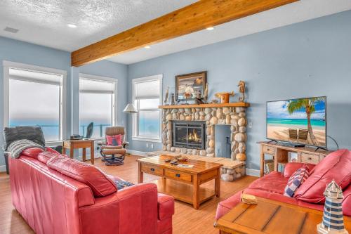 a living room with two red couches and a fireplace at Roads End Light House in Lincoln City