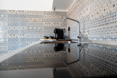 a bathroom with blue and white tiles on the wall at Casa del Moro in Santo Stefano di Camastra