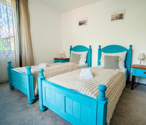 two beds in a room with blueitures at Hotel Ostende in Chocerady