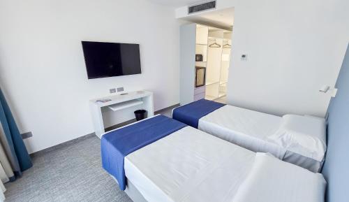 a hotel room with two beds and a tv at Papavero Giallo B&B in Le Castella