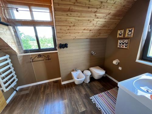 a bathroom with a sink and a toilet and a window at Warmińska Sielanka in Blanki