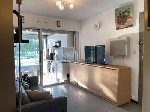 un salon avec une télévision sur un meuble en bois dans l'établissement Studio cosy avec climatisation, WIFI et parking - FR-1-553-234, à Balaruc-les-Bains