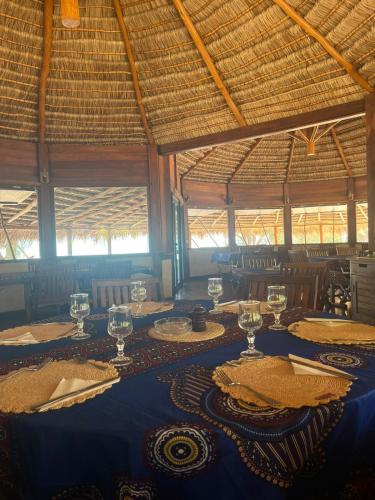 a dining room with a blue table with wine glasses at Hôtel Safari Vezo Anakao in Anakao