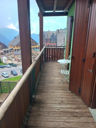 a wooden balcony with a table and chairs on it at Borgo Stalle in Prato Nevoso