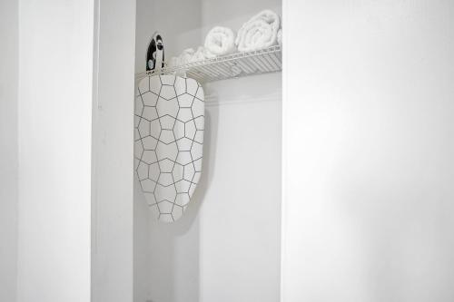 a white closet with a rack of towels and a shoe rack at Elegant Wynwood Flats in Miami