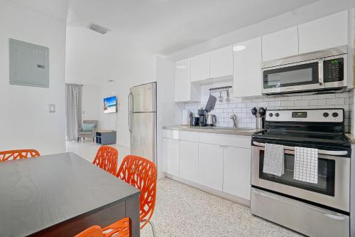 a kitchen with white cabinets and a stove top oven at Elegant Wynwood Flats in Miami